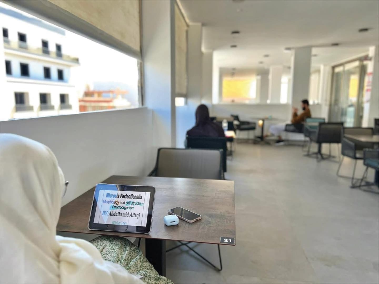 Person working on tablet at terrace table with city views