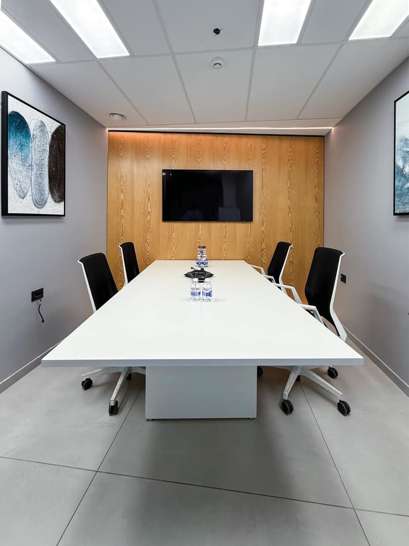 Focus Room - 6-seat table with wooden accent wall, TV, and framed artwork